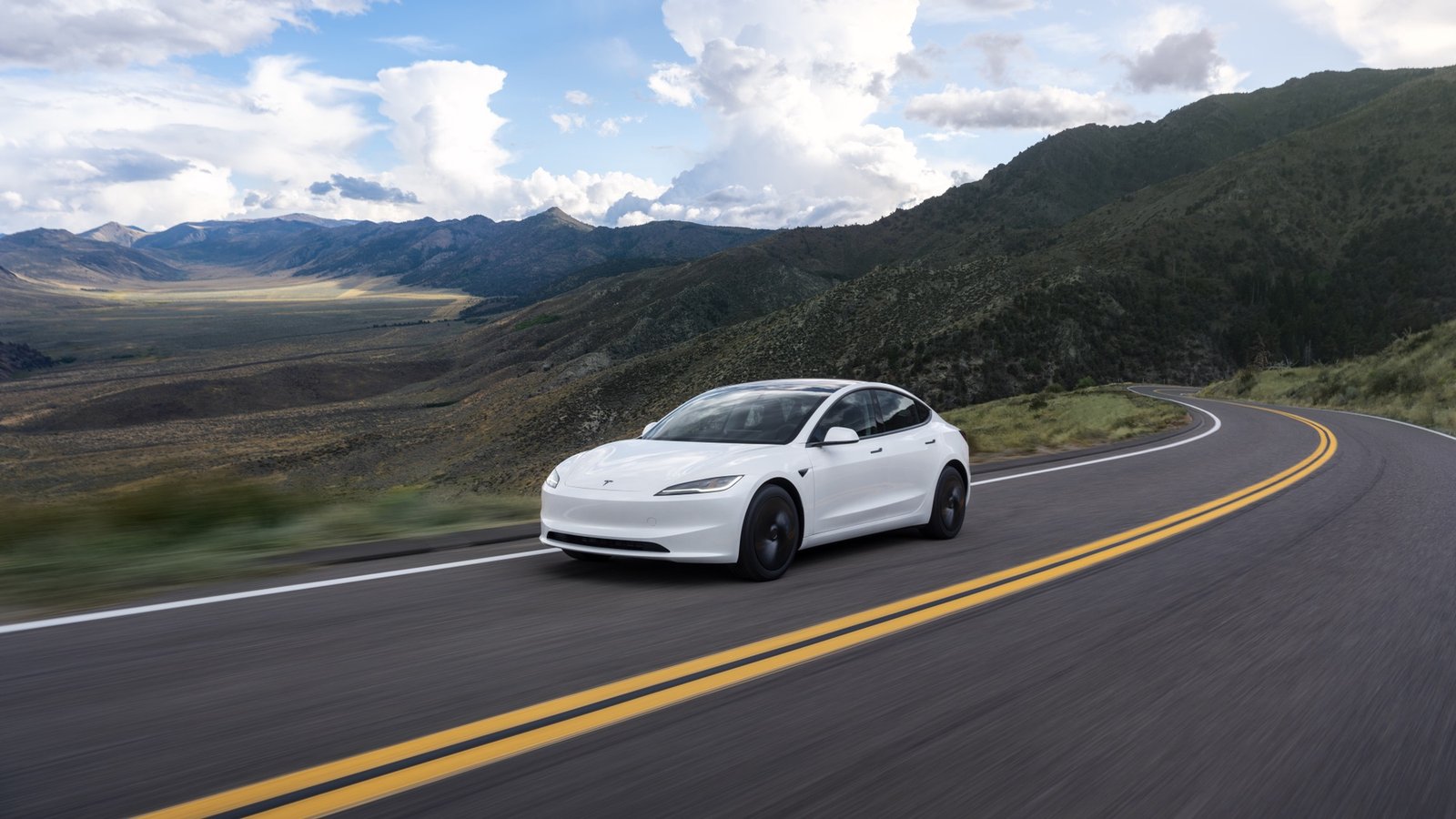 Tesla Model 3 blanco circulando por una carretera de montaña