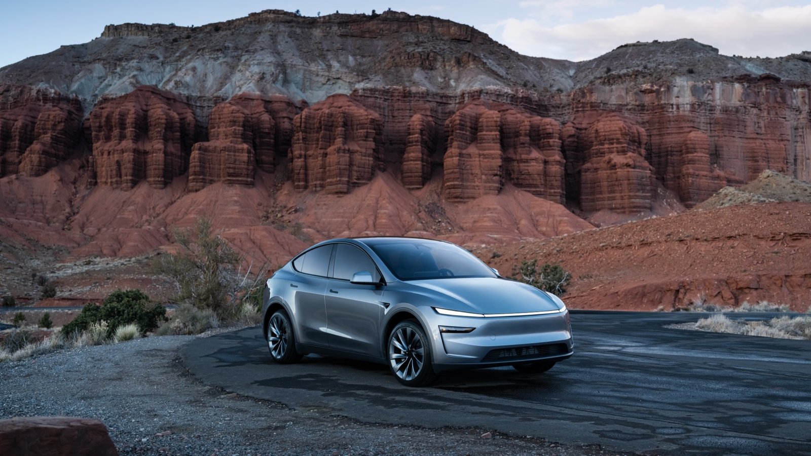 Grey Tesla Model Y parked in a red-rock landscape