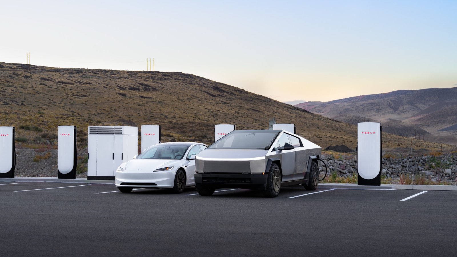 White Tesla Model 3 and Cybertruck charging at a Supercharger station at sunset
