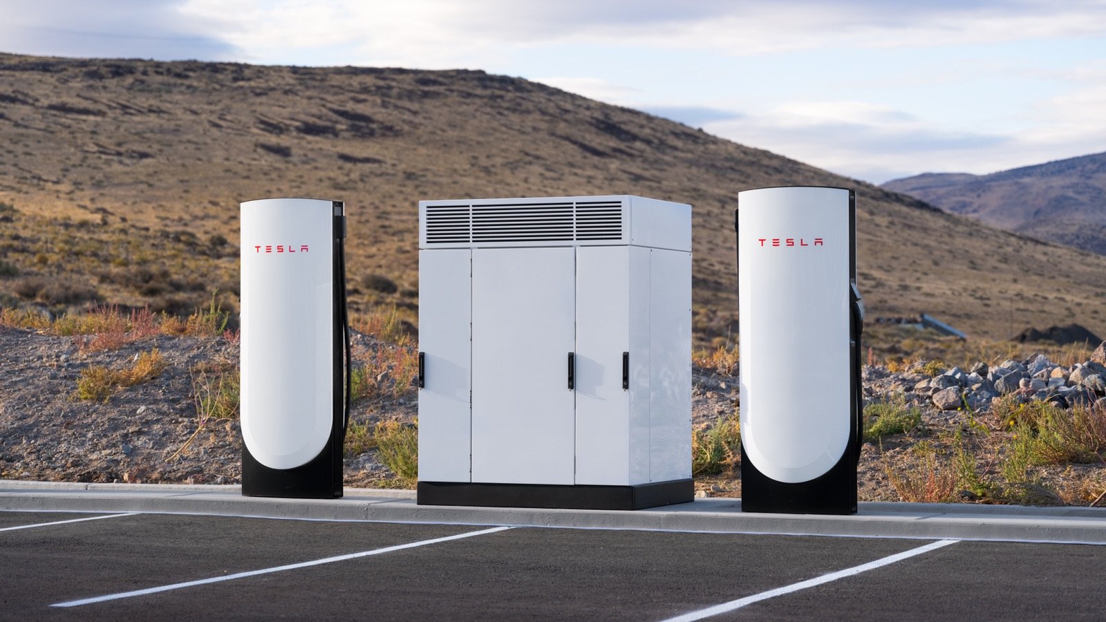 Row of Tesla V4 Supercharger power cabinets in a desert landscape