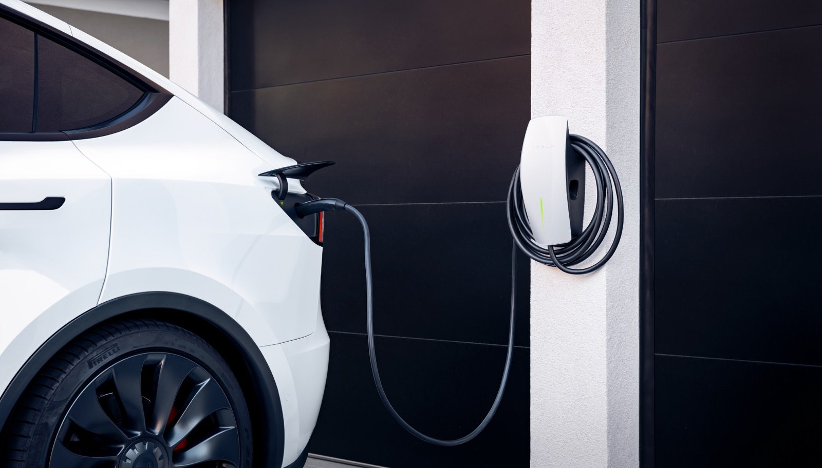 Tesla Wall Connector cable coiled next to a garage wall